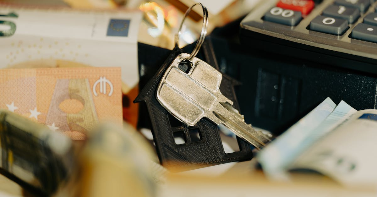 House keys rest on a keychain with euro banknotes and calculator, symbolizing real estate investment.