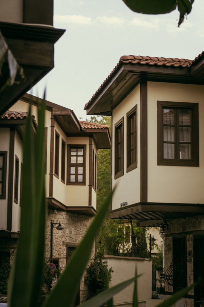 Traditional wooden houses with balconies, showcasing classic architectural style amidst greenery.